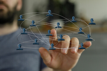 Visual representation of interconnected individuals. Digital illustration of a network held by a human hand, communication and teamwork