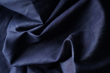 Obraz premium Wrinkled Denim Cloth Close-Up Texture Background. Detailed Denim Textile Background in Dark Blue Color. High Quality Denim Fabric Texture for Fashion and Textile Use. Indigo Denim Textile Background