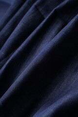 Obraz premium Wrinkled Denim Cloth Close-Up Texture Background. Detailed Denim Textile Background in Dark Blue Color. High Quality Denim Fabric Texture for Fashion and Textile Use. Indigo Denim Textile Background