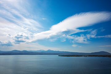 A large cloud is floating over a calm body of water