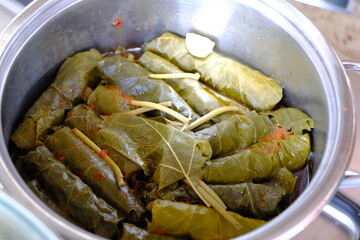Close-up of homemade stuffed vine leaves in a pot. Stuffed vine leaves with meat cooked in a pot. Traditional Turkish cuisine. Home cooking. Healthy eating.