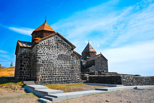 The old Sevan Monastery Sevanavank building has a steeple and is surrounded by a stone wall