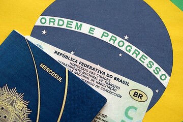 Brazil National Drivers License for a motor vehicle with passport on Brazilian flag close up
