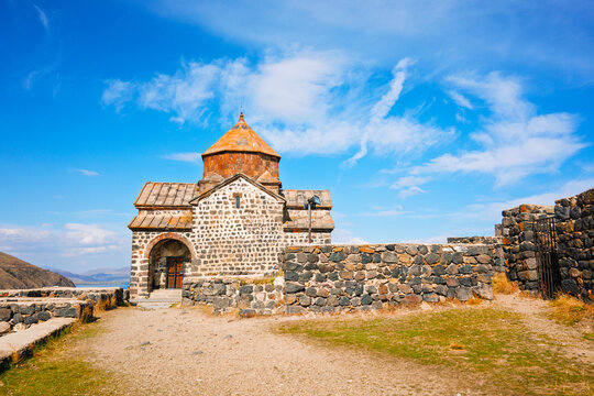 A Sevan Monastery Sevanavank church with a steeple sits on a hillside
