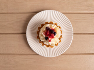 Top View of Tartlet with Cream and Berries on White Plate