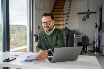 Fototapeta premium Mature man working from home office smiling during video call