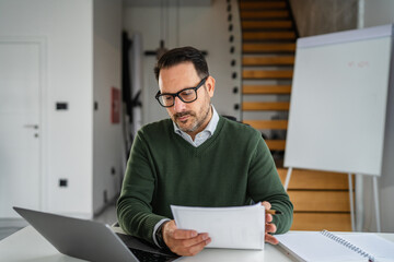 Man working from home making notes and paperwork