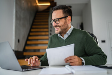 Man working from home making notes and paperwork