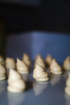 Raw choux pastry dough for homemade desserts on baking sheet