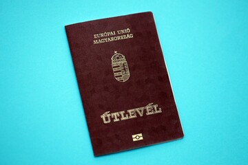 Hungarian passport book on light blue paper background close up. Travel document on blue surface