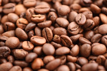 Big pile of fresh roasted brown coffee beans as flat background photo image with visible details close up