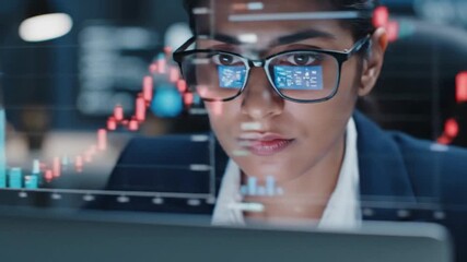 Focused businesswoman analyzing data on a computer screen in a modern office environment - Powered by Adobe