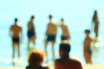 A blurry photo of people on the beach. People sunbathing on the beach in summer.