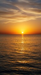 Fototapeta premium A breathtaking golden hour sunset painting the wide sky above the calm ocean water, where the natural horizon line separates the elements perfectly ,nature ,peaceful ,outdoor