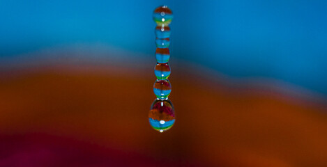 A series of water droplets are captured in mid-air,