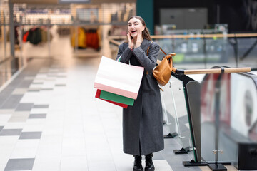 Woman with different shopping bags in mall, space for text