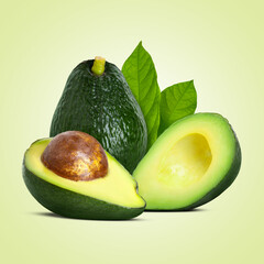 Fresh avocados and green leaves on beige background