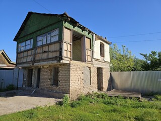 abandoned two-story building in a state of disrepair with missing windows and signs of weathering...