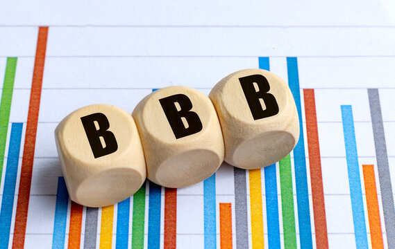 Wooden blocks with bbb abbreviation on colorful financial chart background representing credit
