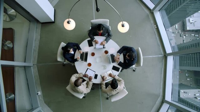 team brainstorm session, creative group working together in studio environment, design professionals gathered around table designing prototypes and discussing ideas in vibrant studio setting