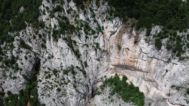 4k aerial footage showing steep limestone cliffs and forested slopes of Lazar Canyon in eastern Serbia during spring. Bottom-up movement