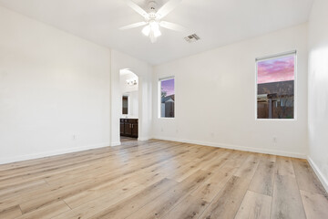 Spacious empty living room with hardwood floors and ceiling fan