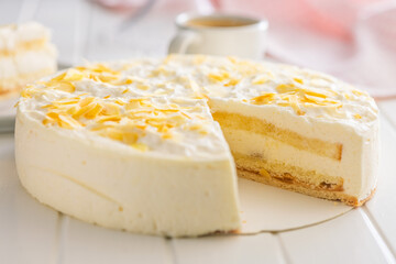 Sweet creamy cake on white table.