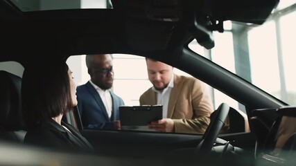 A man and woman consult with an African car dealer in a modern showroom about choosing a new vehicle. Concept assisting in car selection.