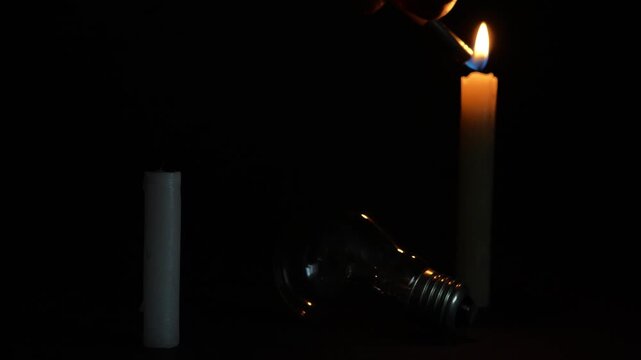 The light bulb is lying on the table. Two candles light near it