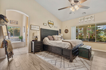 A cozy bedroom featuring a spacious large bed and a cooling ceiling fan