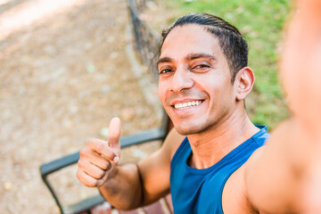 Disabled mid man latin athlete smiling giving thumbs up selfie