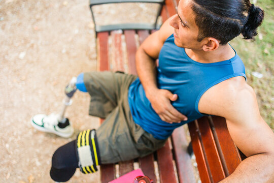 Disabled male athlete resting after training in park