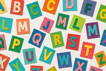 Cutout paper collage alphabet colorful letters scattered on white playful craft typography