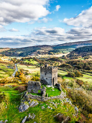 Autumn colours over Castell Dolwyddelan and Eryri Mountains from a drone, Snowdonia, Conwy County Borough, Wales, England