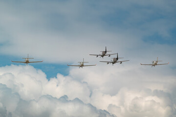 Airplanes Flying in Formation Above Clouds