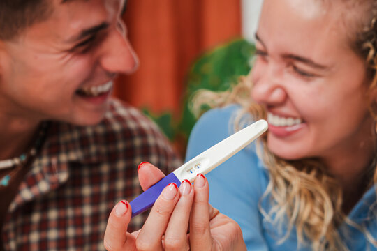 Joyful couple sharing an exciting moment as they examine the positive results of a pregnancy test, filled with happiness and anticipation for their future together as they embrace this new journey.