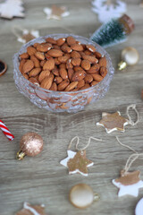 Various Christmas decorations, cookies, chocolate and nuts on wooden background. Selective focus.