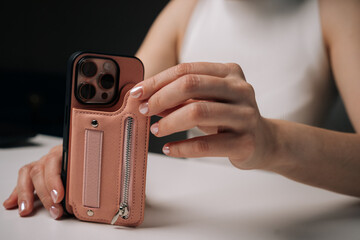 Closeup cropped shot of unrecognizable woman holding sleek smartphone, featuring trendy protective...