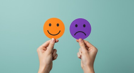 Hands holding happy and sad emoji faces representing emotional choice and feedback on a teal background