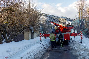 Naklejka premium Two firefighters are standing next to a fire truck