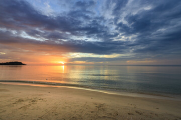 Beautiful sunset over the ocean with a few clouds in the sky