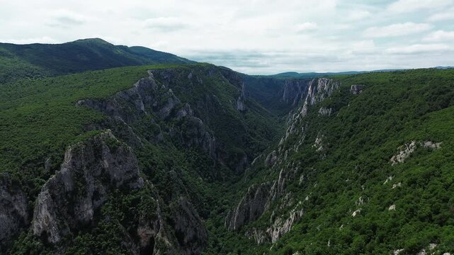 4k aerial drone footage showing the dramatic cliffs and dense forests of Lazar Canyon - Lazarev Kanjon in eastern Serbia, captured on a bright spring day