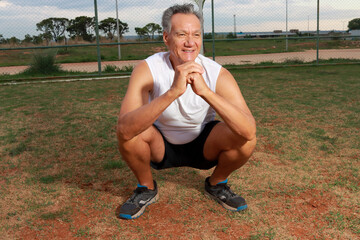Older Man at the Park exercising doing deep squats