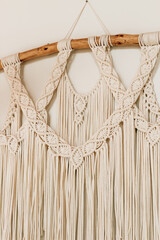 Macrame wall hanging with intricate patterns and elegant fringe in a cozy home setting