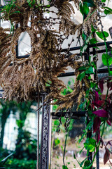 Decorative dried floral wreaths displayed in a botanic garden setting during daylight hours
