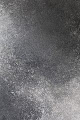 Dark textured surface with shades of gray and black showing natural patterns and depth