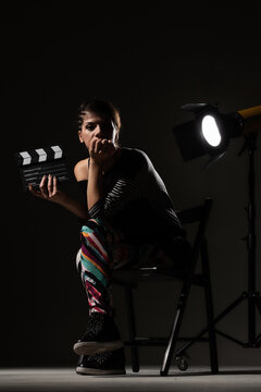 Female movie director. Girl holding clapperboard on set.