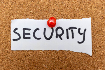 Handwritten word SECURITY pinned to a corkboard. Represents safety, protection, and defense. Ideal for themes related to safety, management, and security services.