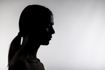 Artistic silhouette of a young woman in a studio setting, subtle and elegant