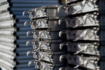 Stacked aluminum scaffolding platforms with secure locking hooks and reinforced structure designed for construction safety and modular industrial assembly systems